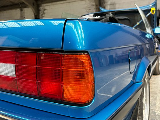 Rear quarter of a blue BMW E30 following restoration and paintwork