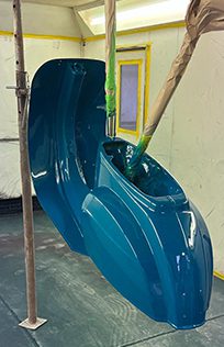 Freshly painted blue bumper drying in the workshop