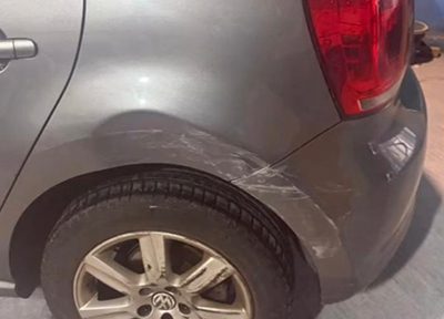 Dent and scuff damage to a car rear quarter panel before body repair