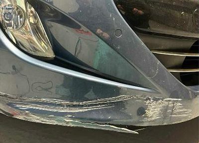 Heavily scuffed front bumper before repair and refinishing